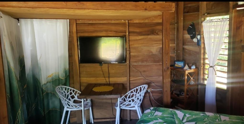 1 dormitorio con TV, mesa y sillas en Seaside Oasis, en Revival