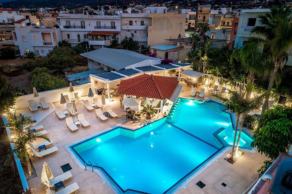 an overhead view of a swimming pool with chairs and a building at Malia Mare Hotel in Malia