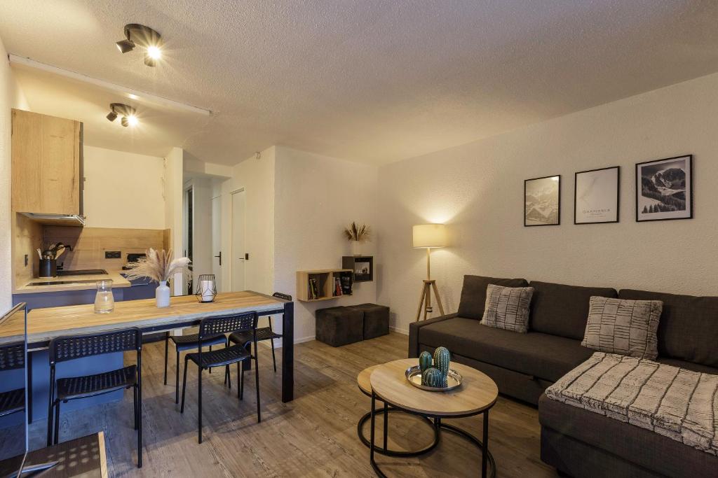 a living room with a couch and a table at Chamonix Sud - Jonquilles 209 - Happy Rentals in Chamonix-Mont-Blanc