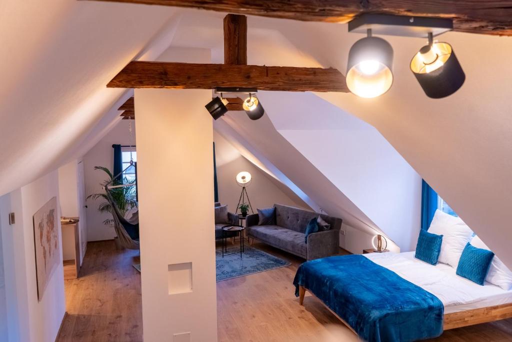 a attic bedroom with a bed and a couch at Ruhig und Zentral an der Donau in Ulm