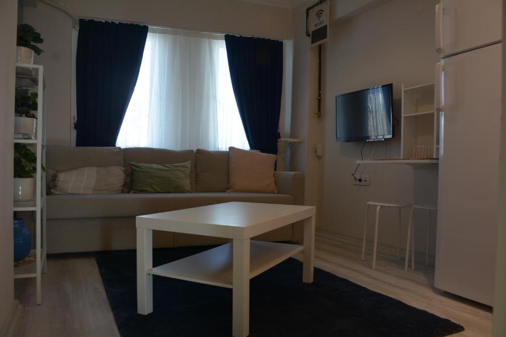 een woonkamer met een bank en een tafel bij HOUSE KA HANIM in Canakkale