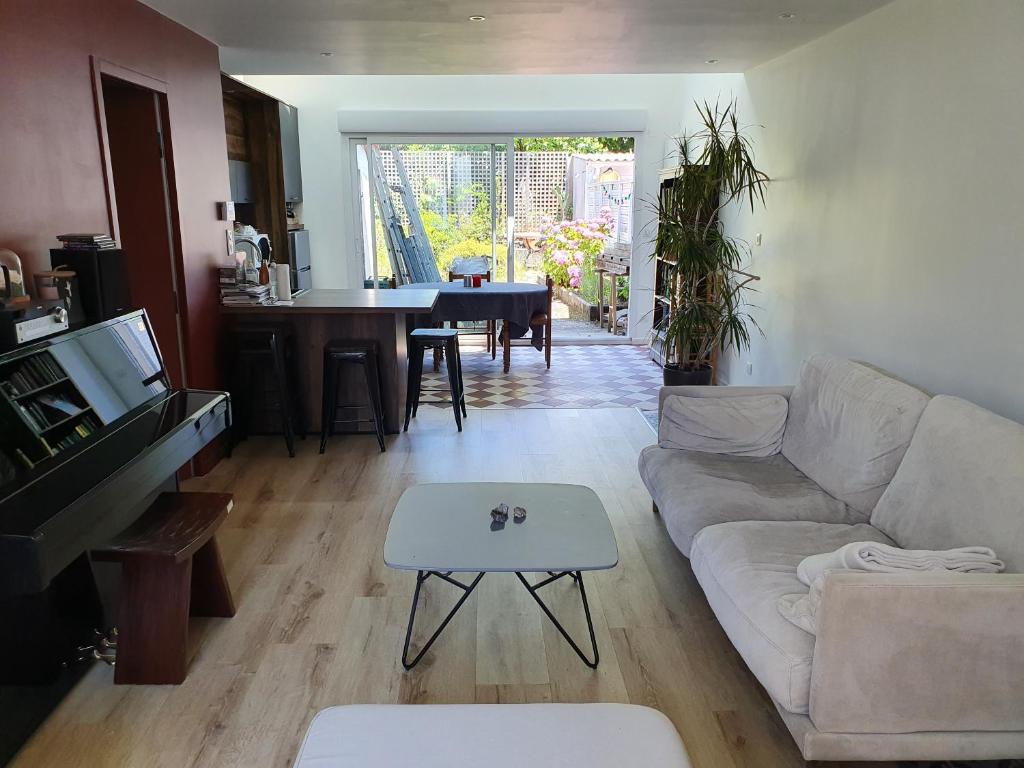 een woonkamer met een bank en een tafel bij Chambre privée chez l'habitant en colocation dans agréable maison avec jardin - Private room in a shared house with garden in Bordeaux