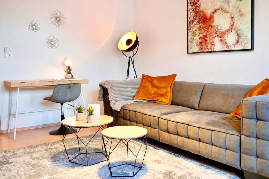 - un salon avec un canapé et une table dans l'établissement Design Apartment - Boxspringbett - Waschmaschine - 55 Zoll Smart-TV - Netflix inklusive - Arbeitsplatz, à Magdebourg
