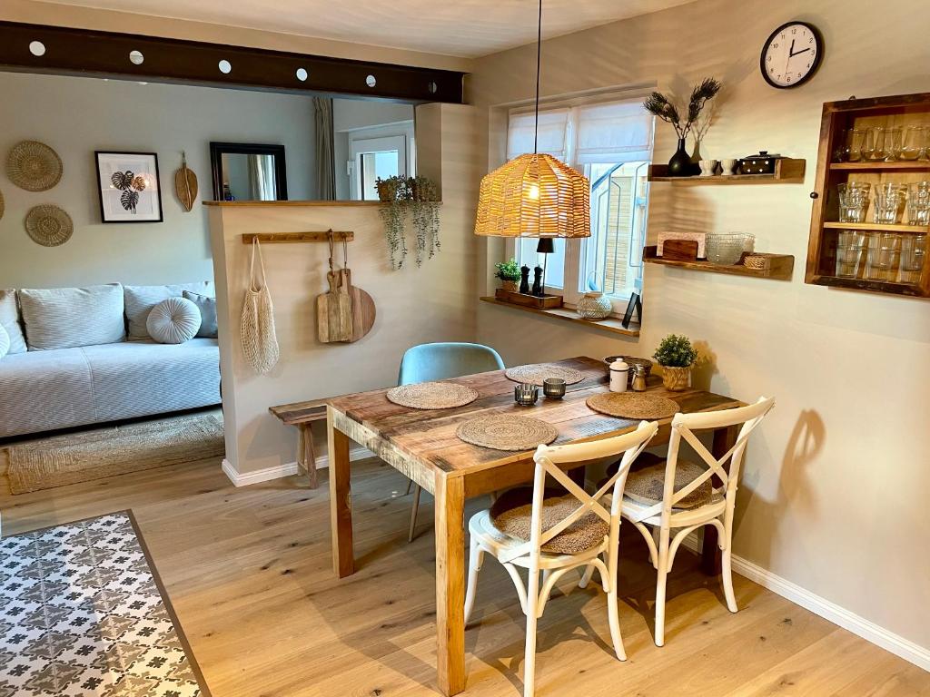 新城荷斯坦的住宿－Neue Hafenliebe，一间带木桌和椅子的用餐室