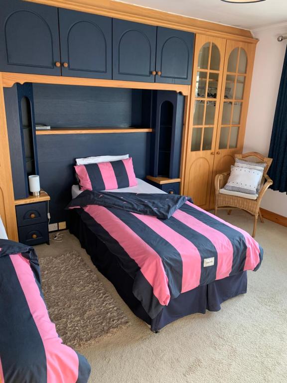 a bedroom with a bed with pink and blue at Rocklands Guesthouse in Castlebar