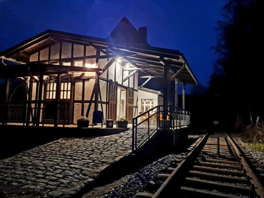 une gare de nuit avec des pistes devant elle dans l'établissement Museumsbahnhof Ahütte, à Üxheim