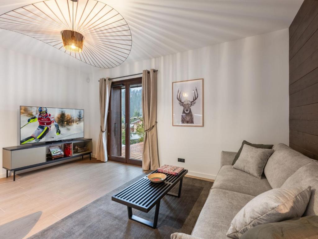 un salon avec un canapé et une télévision dans l'établissement Appartement proche pistes avec jardin, parking, casier à ski - 5 min à pied du centre de Megève - FR-1-569-138, à Megève