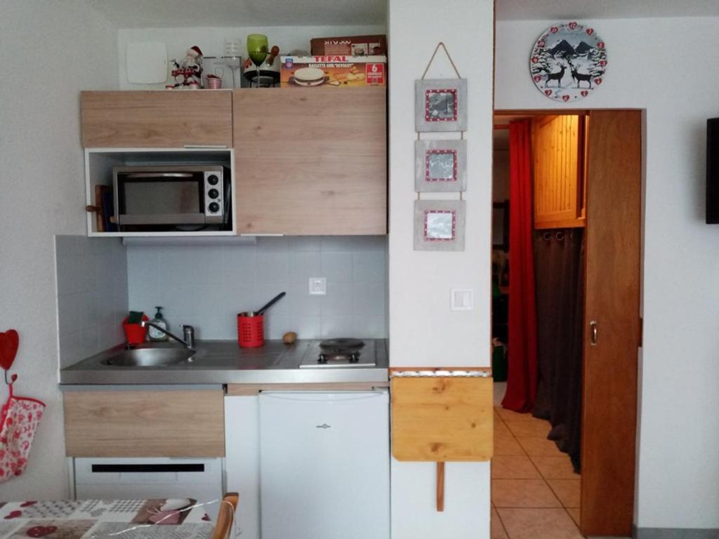 une petite cuisine avec un évier et un micro-ondes dans l'établissement Studio cosy 4 pers, RDC, Sud, à 300m des pistes et 250m commerces, bien équipé, animaux admis. - FR-1-733-116, à Crest-Voland
