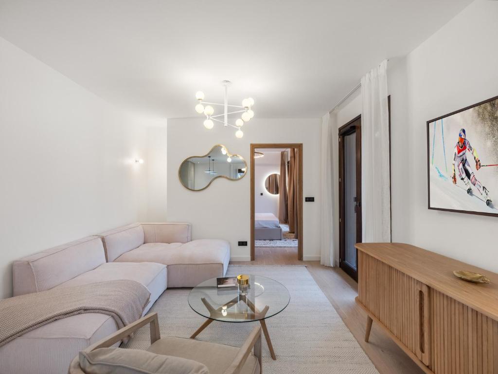 un salon avec un canapé et une table dans l'établissement Appartement moderne 98m² à Megève, proche centre et remontées mécaniques, 6 pers, jardin privatif - FR-1-569-129, à Megève
