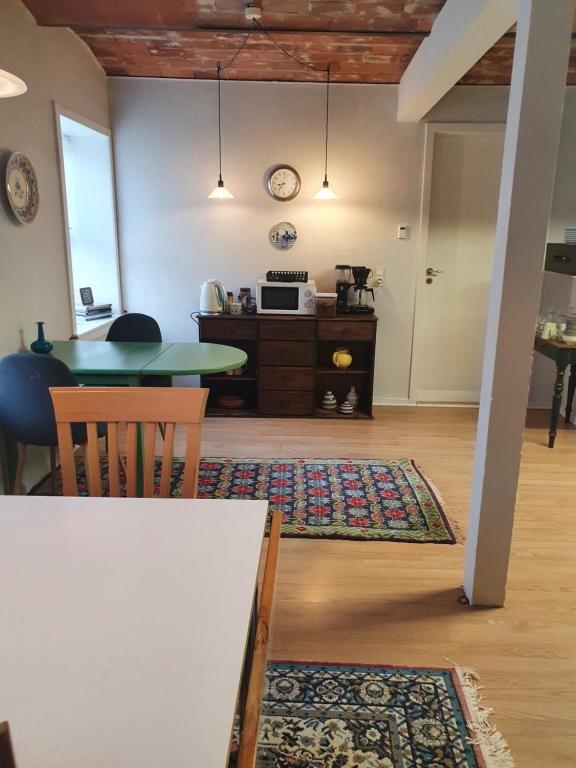 ein Wohnzimmer mit einem Tisch und einer Küche in der Unterkunft Bøelgaarden in Gørding
