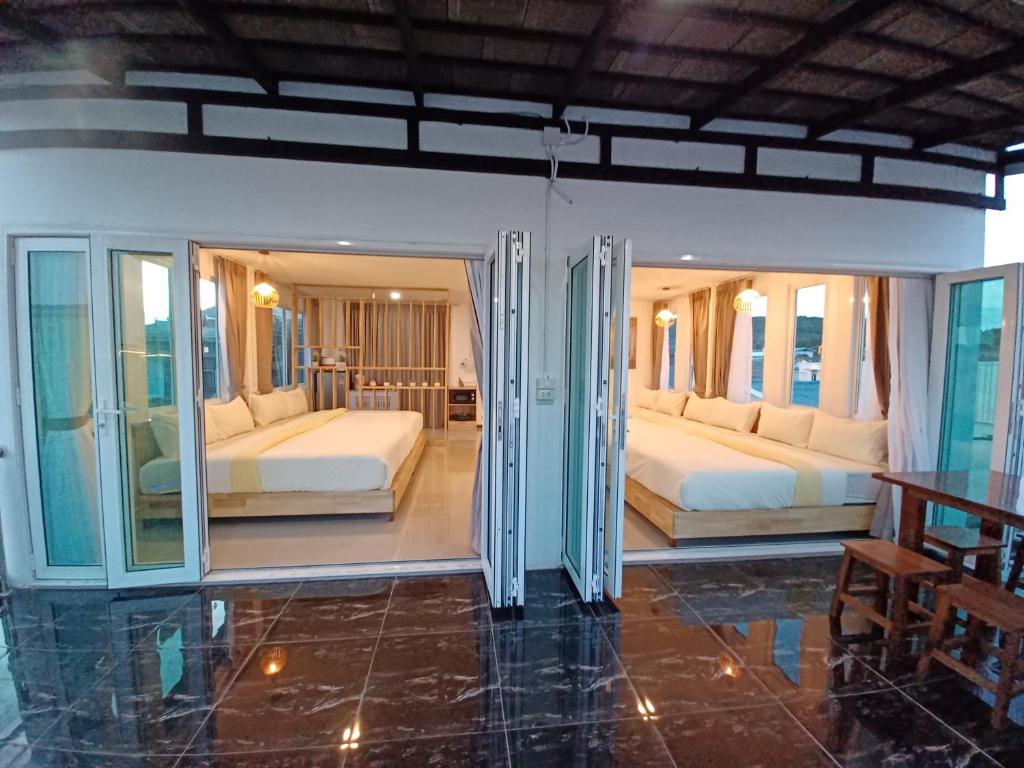 two beds in a room with glass doors at Habor House by Koh Larn Riviera in Ko Larn