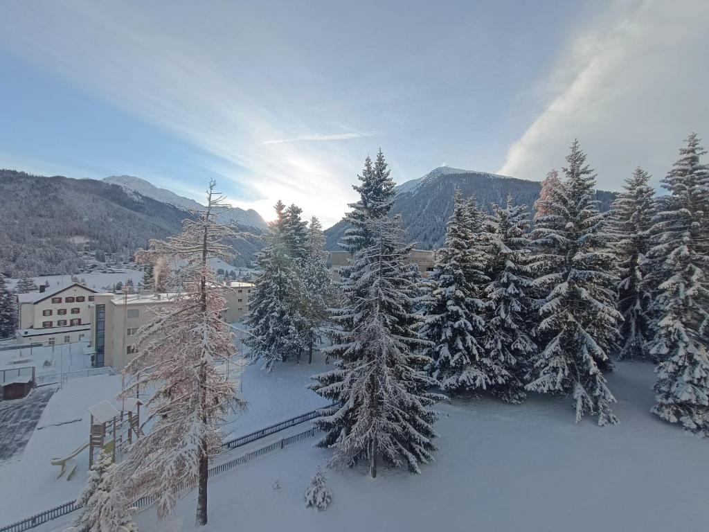 an aerial view of a town with snow covered trees at Ferienwohnung Parsenn Peaks Panorama in Davos