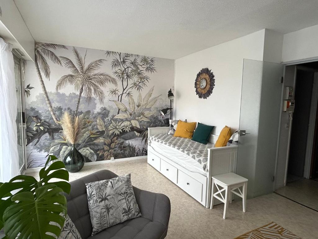 a childs room with a palm tree mural on the wall at Cocon front de mer côté cour in Lacanau
