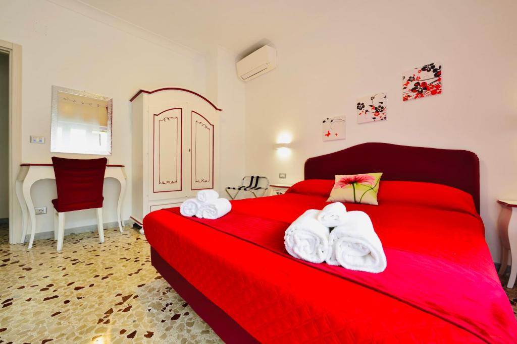 a bedroom with a red bed with towels on it at Floral Holiday in Minori