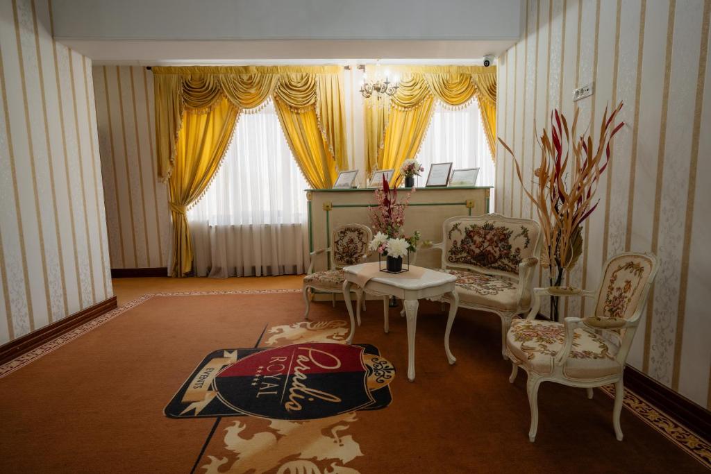 uma sala de estar com uma mesa e duas cadeiras em Hotel Royal em Râmnicu Vâlcea