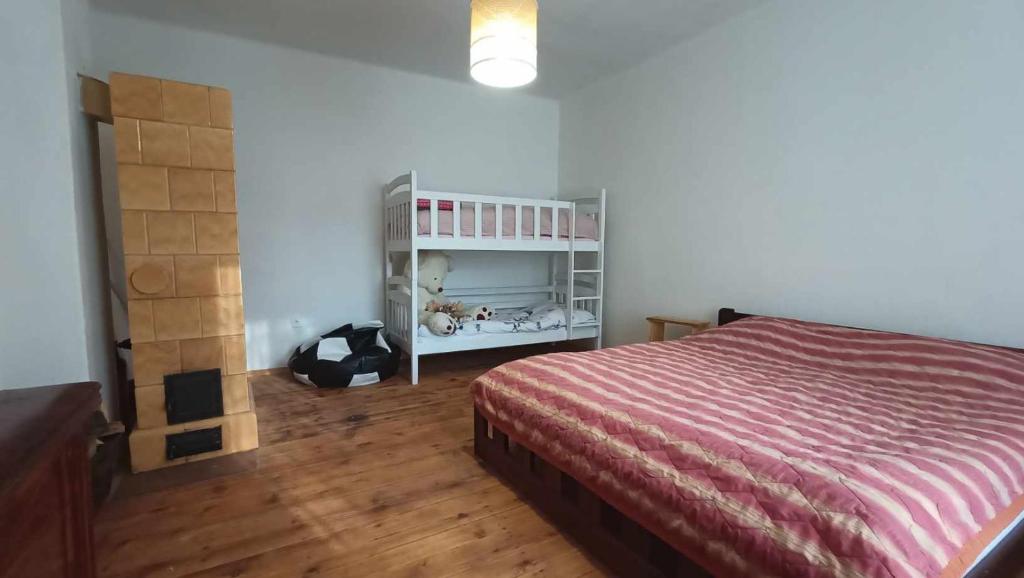 1 dormitorio con 1 cama y suelo de madera en Rodinná chata v rekreačnej oblasti DRIENICA, en Sabinov
