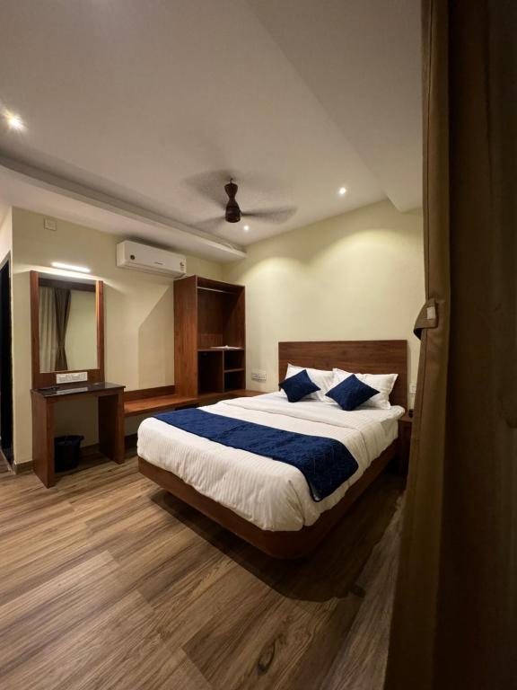 een slaapkamer met een groot bed en een spiegel bij S K Legacy Hotel in Mysore