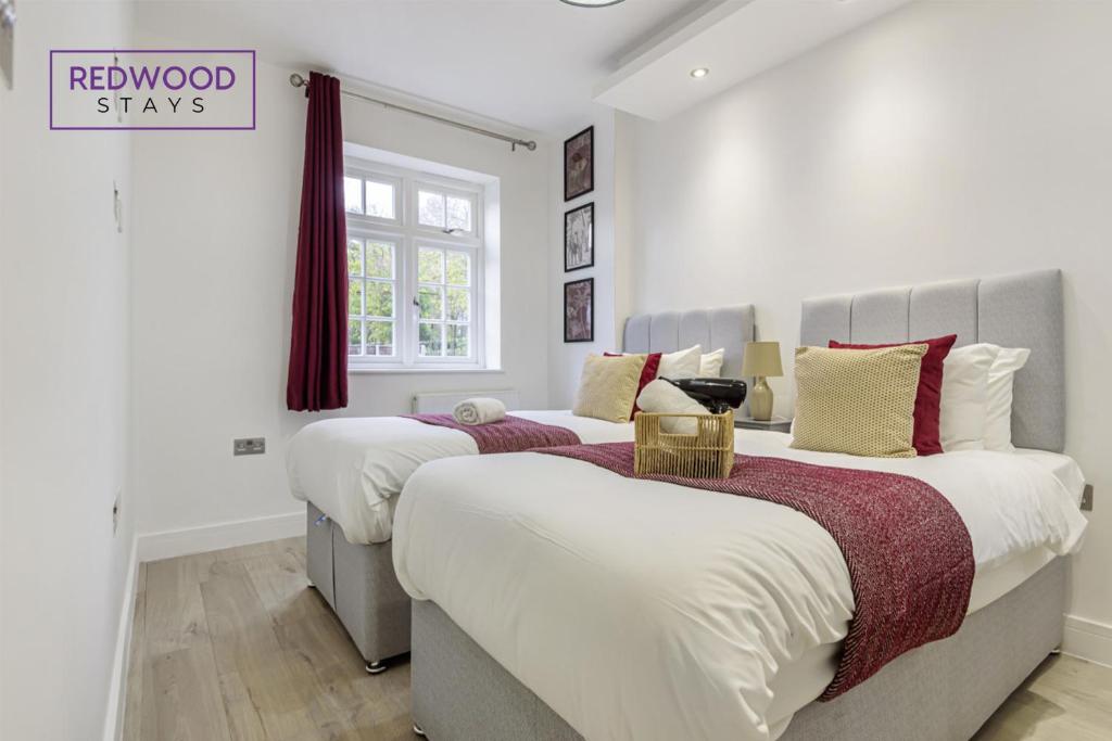 twee bedden in een kamer met witte muren bij 1 Bed 1 Bath Town Center Apartments For Corporates & Contractors, FREE Parking, WiFi & Netflix By REDWOOD STAYS in Aldershot