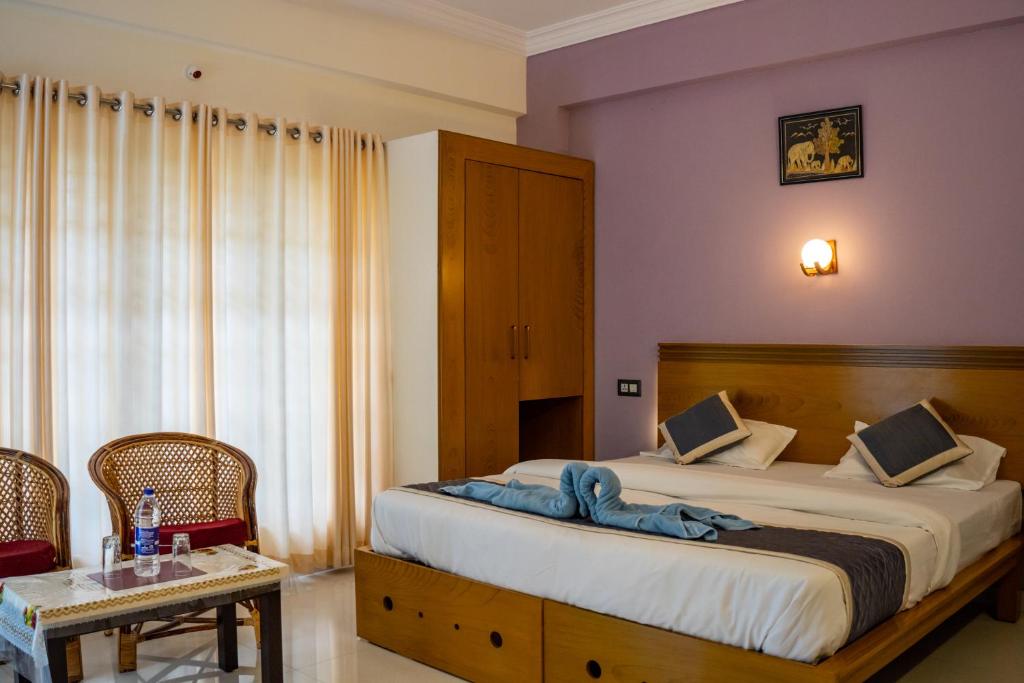 um quarto com uma cama com um cobertor azul em White House Residency em Varkala