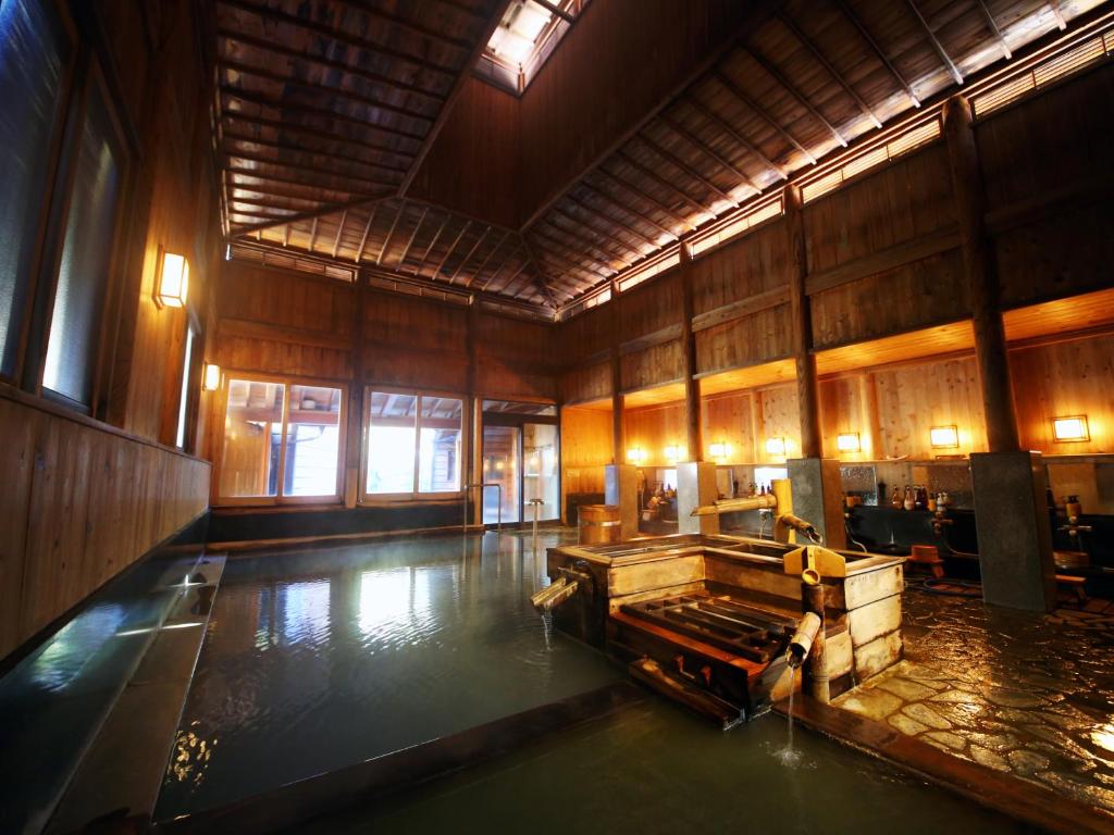 Habitación grande con piscina de agua en el suelo en Ryokan Sakaya, en Nozawa Onsen