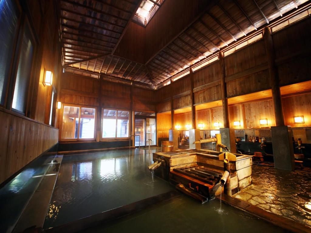 a large room with a pool of water in the floor at Ryokan Sakaya in Nozawa Onsen