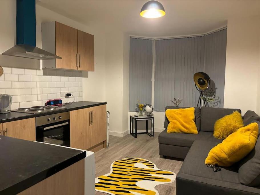 a living room with a couch and a kitchen at Apartment Near Leeds City Centre Sleeps 4 in Beeston Hill