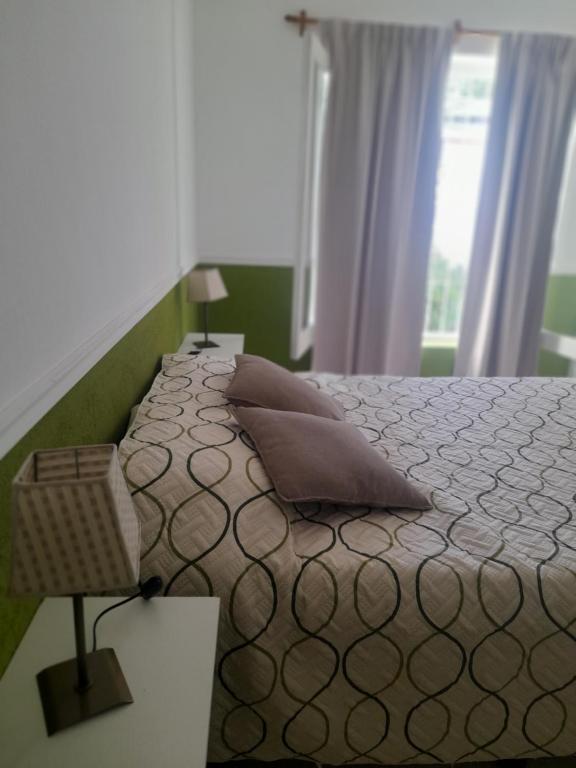 een slaapkamer met een bed met twee kussens en een raam bij LA CUECA in La Cieneguita