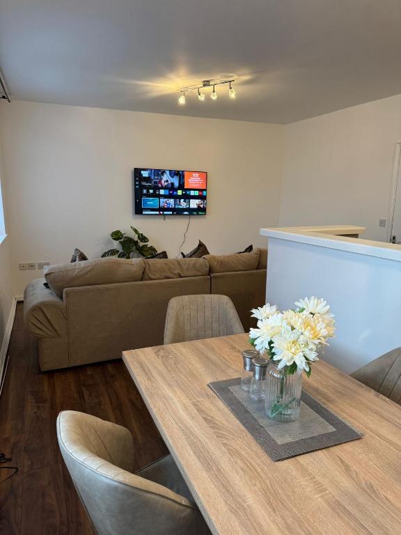 een woonkamer met een tafel en een bank bij Manchester Cosy flat close to City Centre and City stadium in Manchester