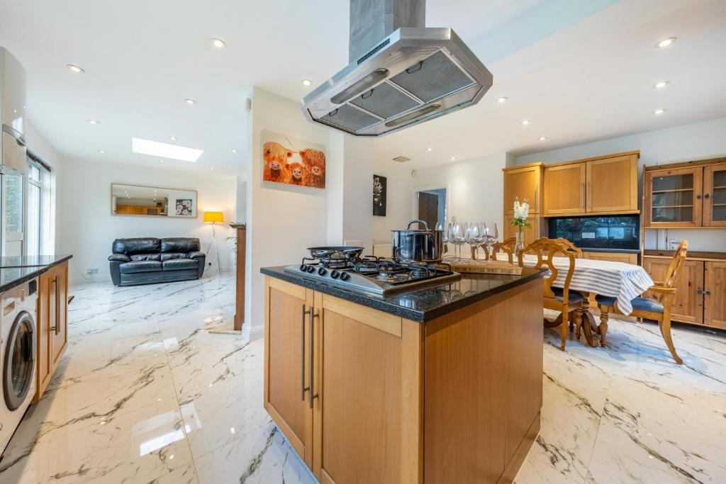 a kitchen with a stove top oven next to a living room at Wembley Stadium 5 Bed House in Wembley