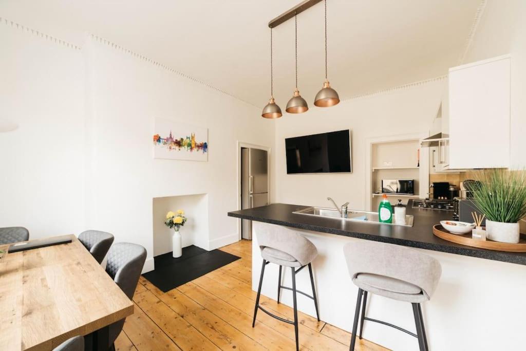 a kitchen and living room with a table and chairs at Central 4-bed House, 10 min Walk to Sights in Bath
