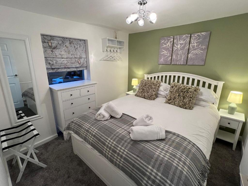 a bedroom with a bed with towels on it at Central Brentwood House in Brentwood