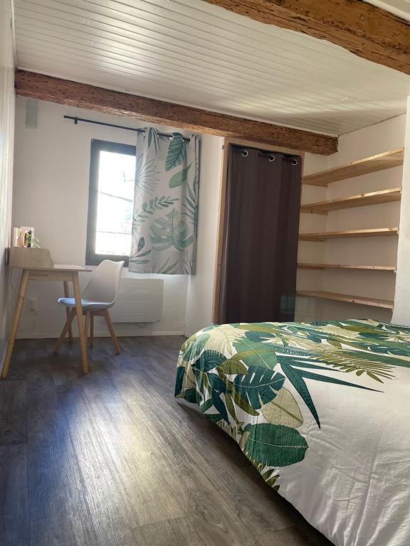 a bedroom with a bed and a desk and a window at Nid douillet avec vue cathédrale in Digne-les-Bains