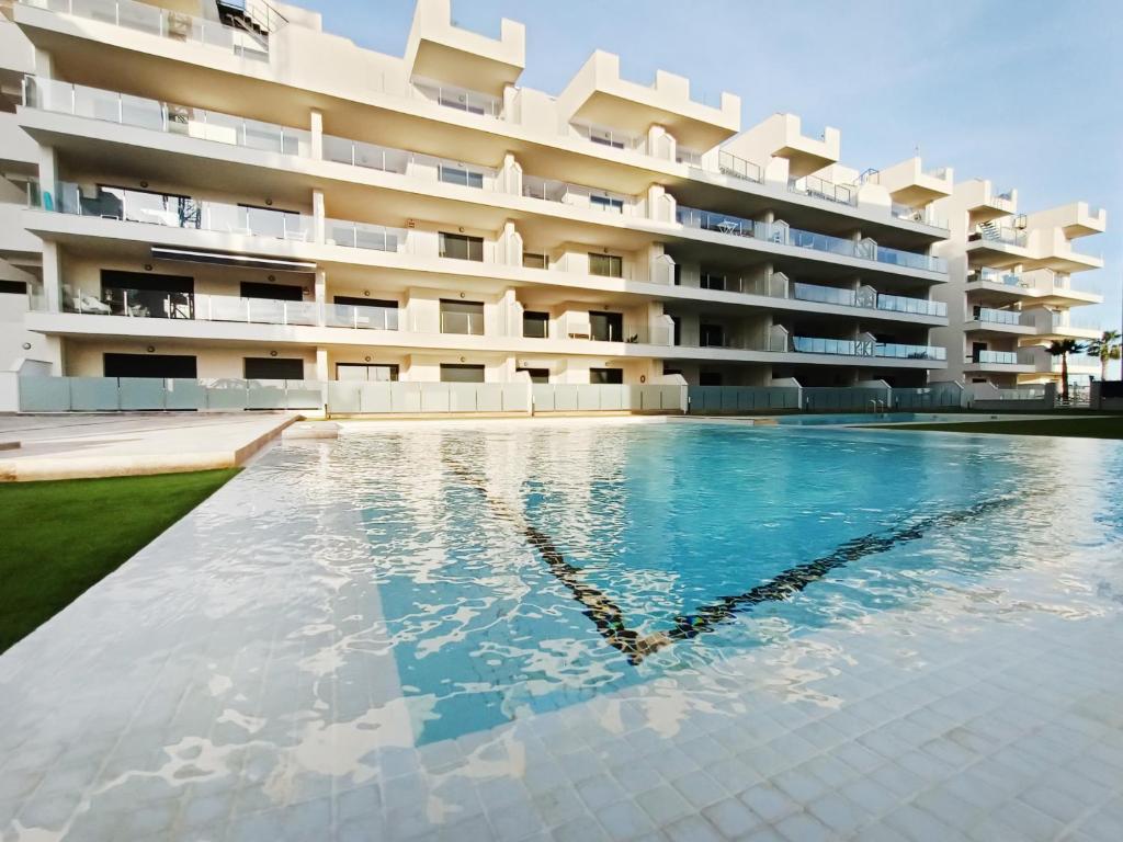 a swimming pool in front of a building at Los Alcazares Velapi - 0810 in San Javier