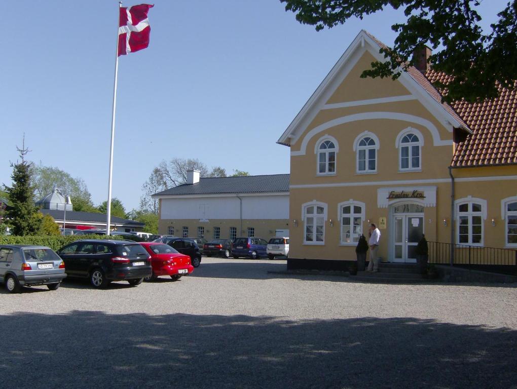 a large yellow building with a flag on top of it at Hotel Frøslev Kro in Padborg