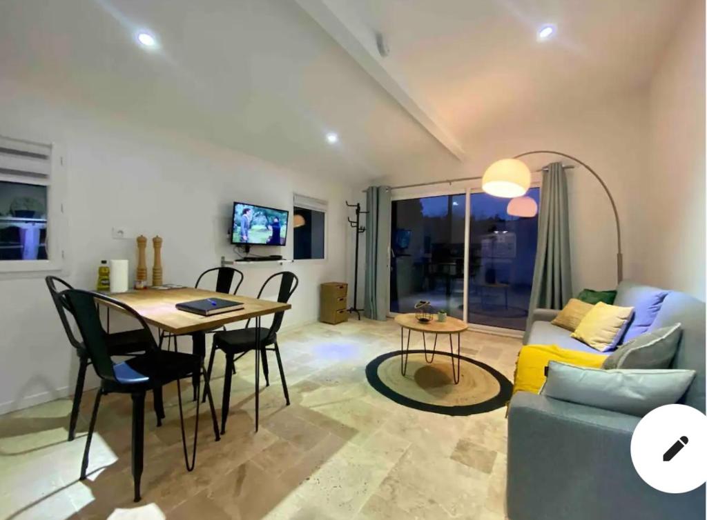 a living room with a table and a couch at La Maison Patricia in Aramon