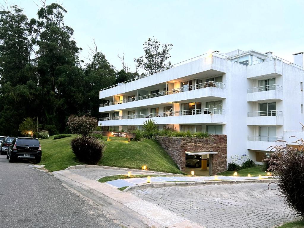 a white building with a car parked in front of it at Altos del Golf - Fito in Punta del Este