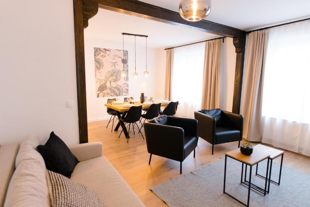 a living room with a couch and a table with chairs at Staylight City-Suite, zentrale Lage, Wintergarten, Premium Appartement in Hildesheim