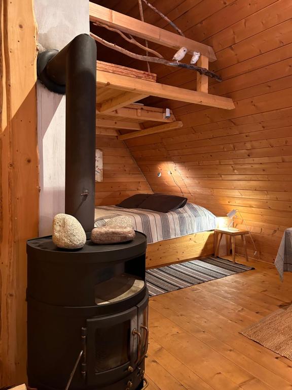 uma cabana de madeira com um fogão a lenha num quarto em DZIUPLA - Berghaus in der Tatra mit Holzsauna em Brzegi