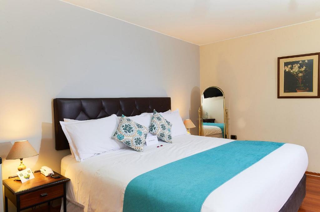 1 dormitorio con 1 cama grande con manta azul en Hotel Los Tambos Colonial, en Arequipa