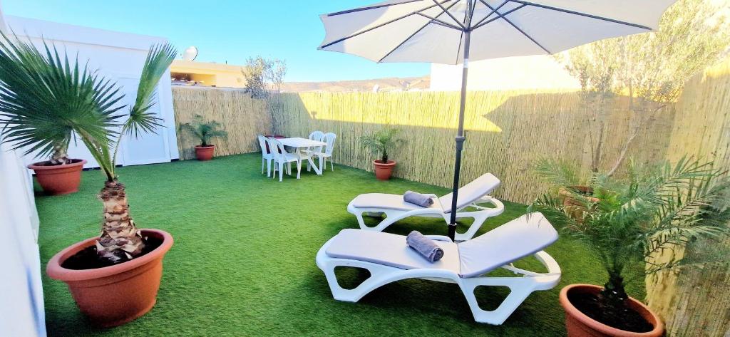 a patio with chairs and an umbrella and a table at Beach Appartment close to Marina 105 sqm in Agadir