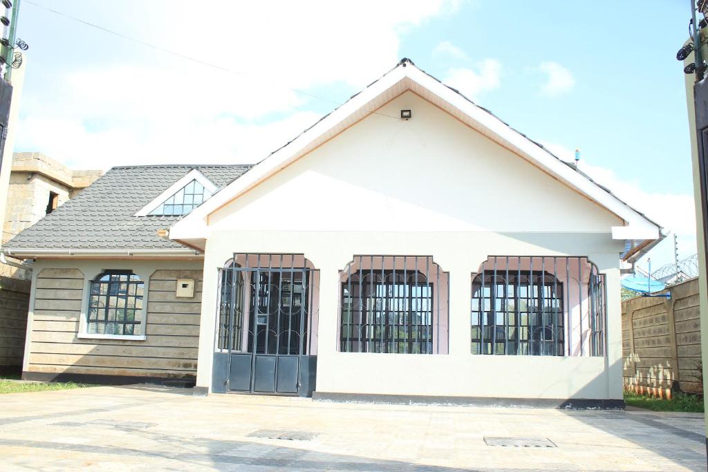 a large white house with a garage at Ms Safari in Thika