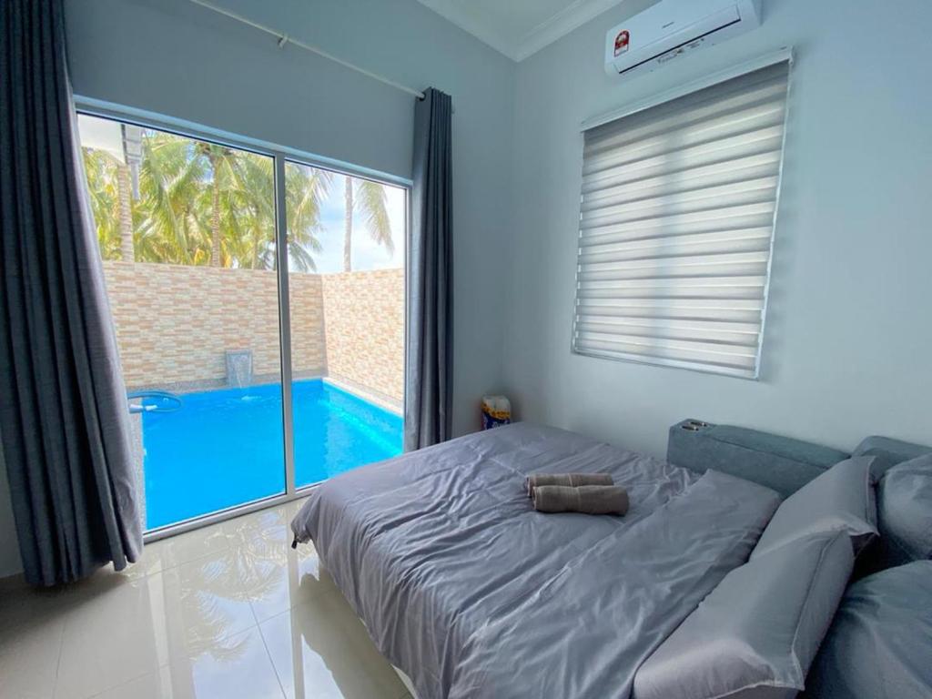 Schlafzimmer mit einem Bett und Poolblick in der Unterkunft Homestay Sekinchan with Private Pool in Sekinchan