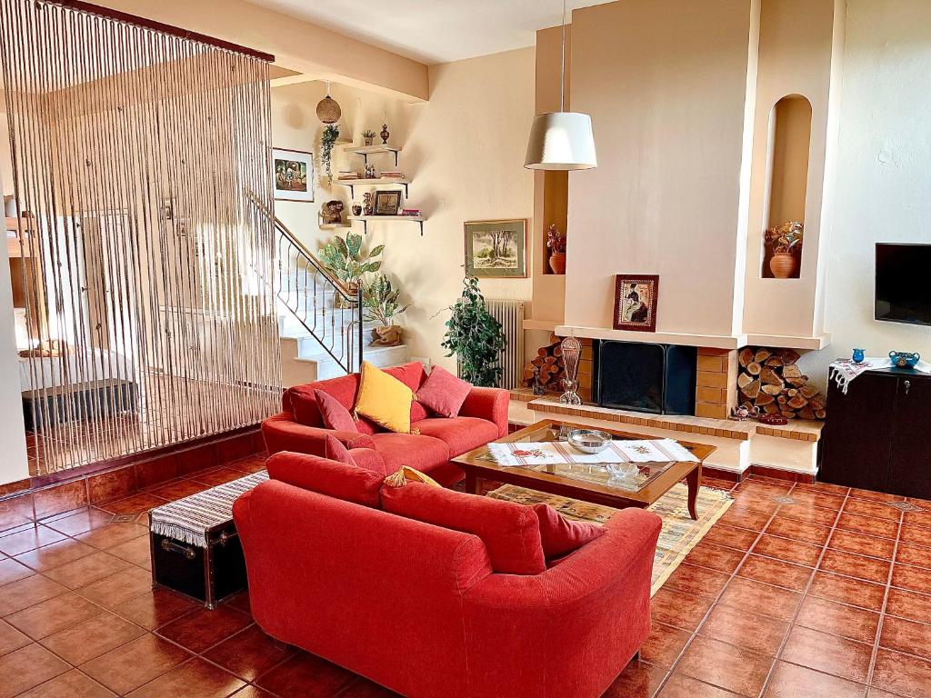 a living room with red chairs and a fireplace at Modus Operandi in Kavála