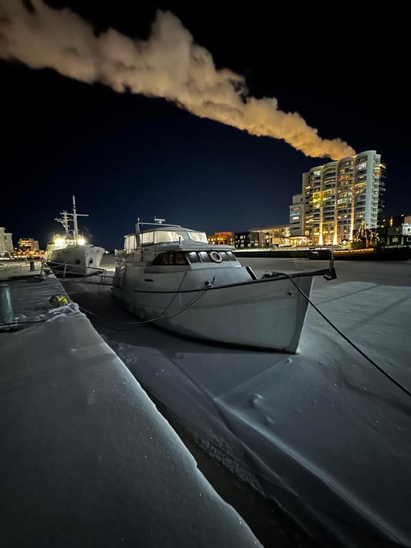 two boats are docked in a harbor at night at Houseboat Crescendo, a Floating Experience in Oulu