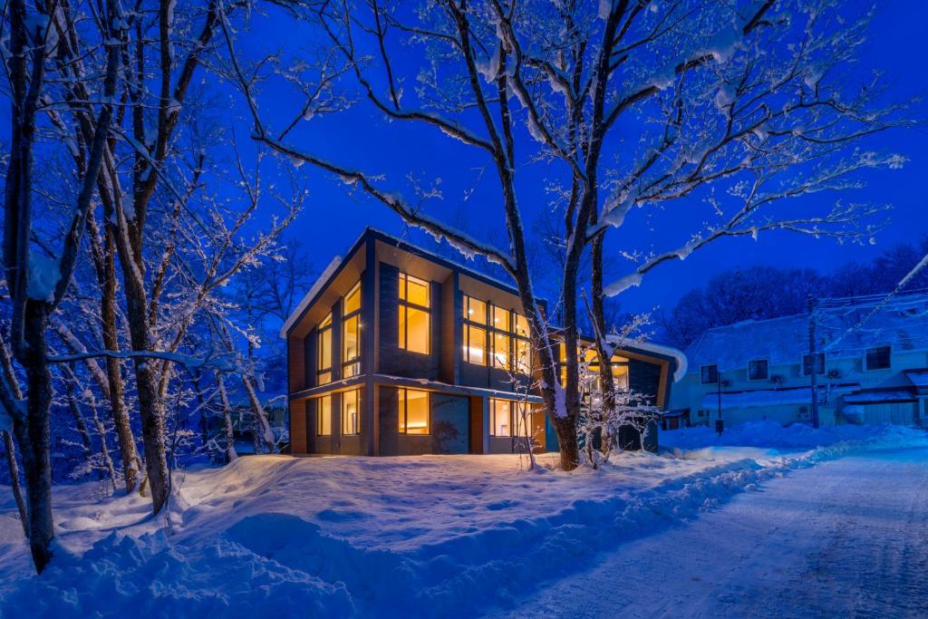 una casa nella neve di notte di Villa Lily by Hakuba White Fox Company a Hakuba