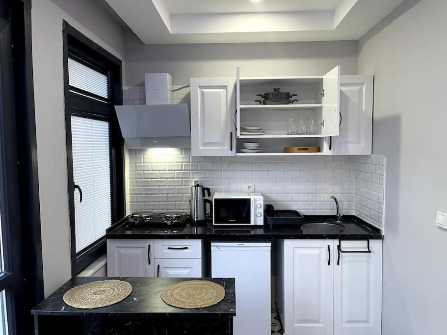 een keuken met witte kasten en een zwart aanrecht bij Comfortable and luxurious flat 4 in Istanbul