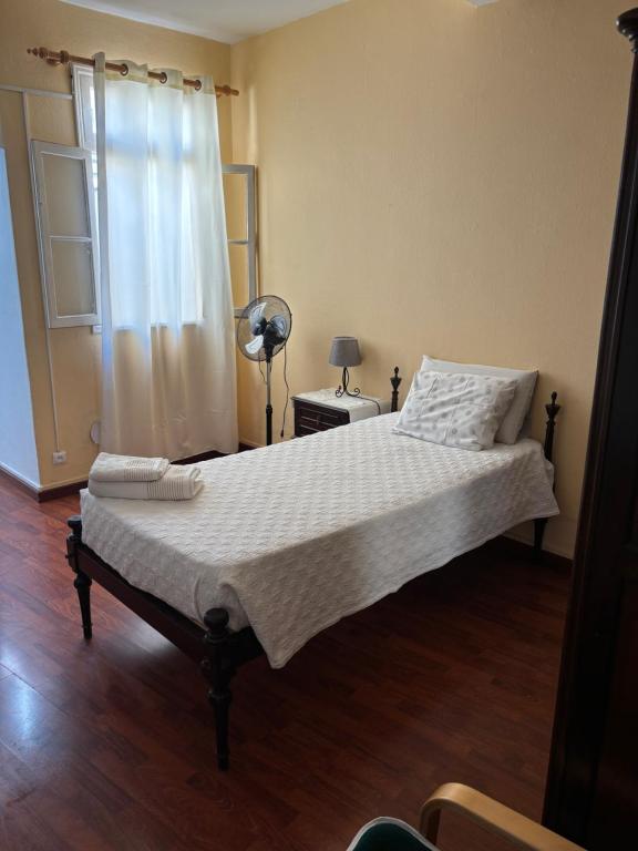 a bedroom with a bed with a white bedspread and a window at Cc39-Q6 in Funchal