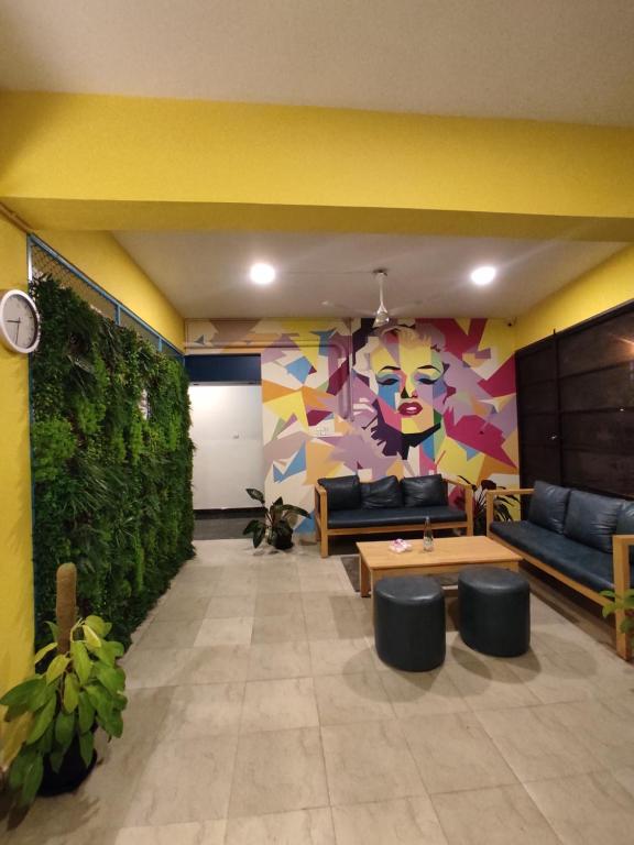 a living room with couches and a green wall at Zylo Indiranagar in Bangalore