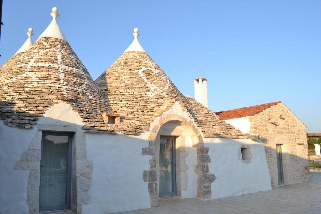 uma antiga casa de pedra com telhado de azulejo em Trulli Don Diego em Noci