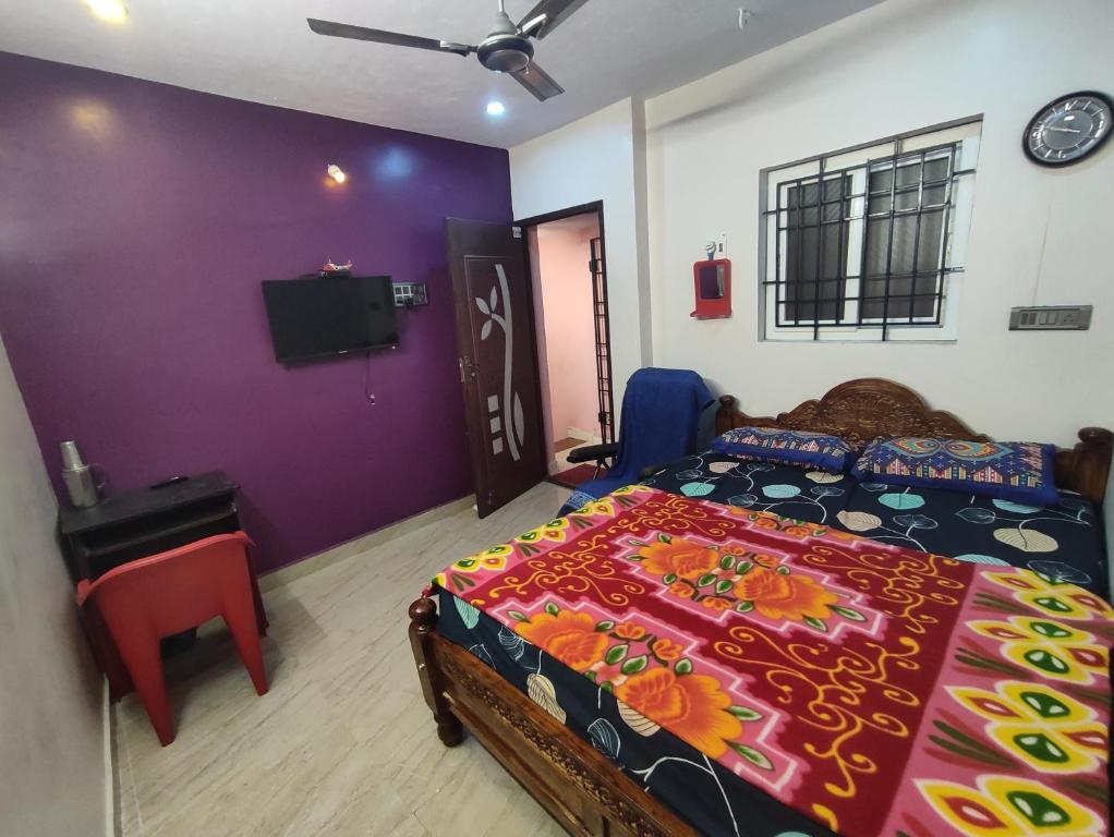1 dormitorio con 1 cama y TV en la pared en Blue Diamond, en Chennai